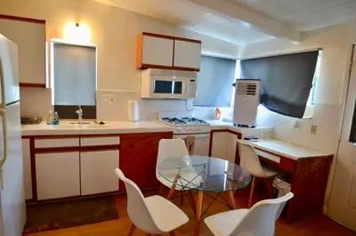 a small kitchen with a glass table and white chairs at Ocean View 5 BR with 3 decks and spa in San Diego