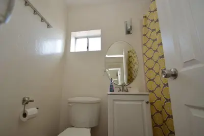 a white bathroom with a toilet and a mirror at Ocean View 5 BR with 3 decks and spa in San Diego