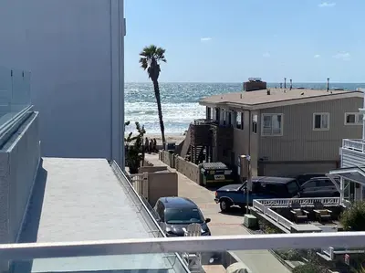 a view of a beach with a palm tree and cars at Ocean View 5 BR with 3 decks and spa in San Diego