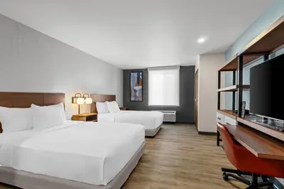 a hotel room with two beds and a flat screen tv at Everhome Suites Temecula in Temecula