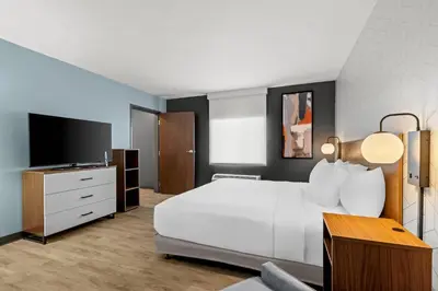 a bedroom with a white bed and a flat screen tv at Everhome Suites Temecula in Temecula