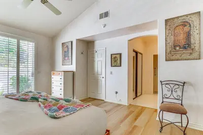 a bedroom with a large bed and a chair at Escondido Townhome with Gas Grill and Golf Acess! in Escondido