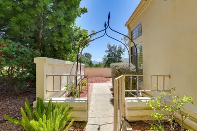 an entrance to a house with a gate with plants at Escondido Townhome with Gas Grill and Golf Acess! in Escondido