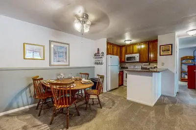 a kitchen with a table and chairs and a refrigerator at Breakwater Escape A 200 in Oceanside