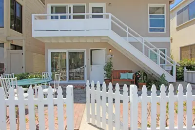 a white picket fence in front of a house at 1009 W Bay in Newport Beach