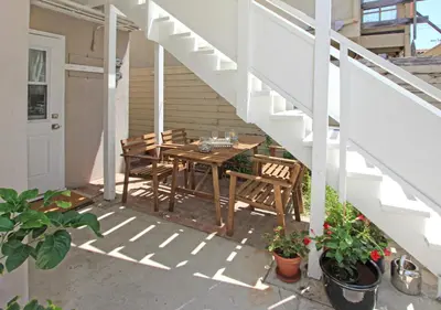a patio with a table and chairs and stairs at 1009 W Bay in Newport Beach