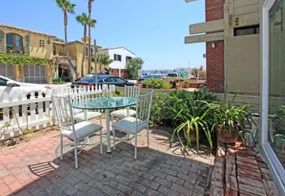 a glass table and chairs on a brick patio at 1009 W Bay in Newport Beach