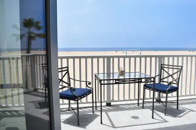 a table and chairs on a balcony with a view of the beach at 1028 W Oceanfront in Newport Beach