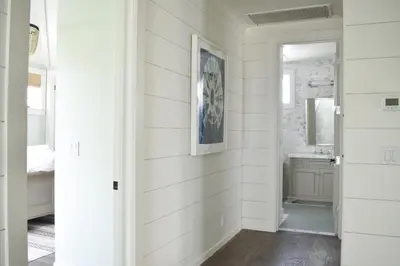 a hallway with white walls and a bathroom with a mirror at 1028 W Oceanfront in Newport Beach