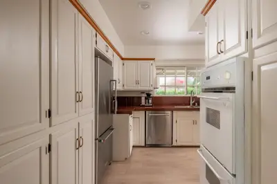 a kitchen with white cabinets and white appliances at La Jolla Shores Family Getaway in San Diego