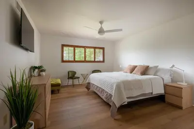 a white bedroom with a bed and a television at La Jolla Shores Family Getaway in San Diego