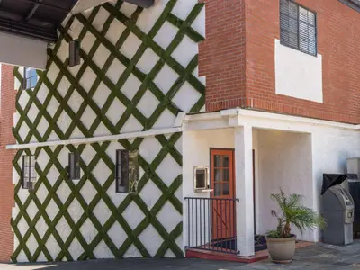 a building with a red and white wall with a door at Ramada by Wyndham San Diego Poway Miramar in Poway