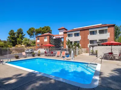 a swimming pool in front of a building at Ramada by Wyndham San Diego Poway Miramar in Poway