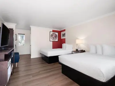 a hotel room with two beds and a flat screen tv at Ramada by Wyndham San Diego Poway Miramar in Poway