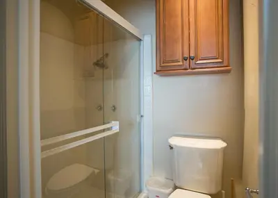 a bathroom with a toilet and a glass shower at Lower West Newport in Newport Beach