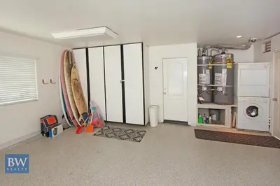 a laundry room with white cabinets and a washer and dryer at 3 Bedrooms in Newport Beach