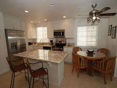 a kitchen with a table and chairs and a counter top at 4 Bedrooms in Newport Beach