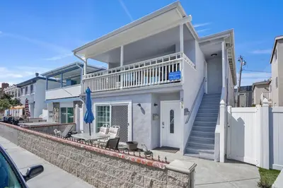 a white house with a staircase and a balcony at 3 Bedrooms in Newport Beach