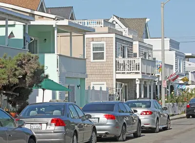 a group of cars parked on a street with houses at 3 Bedrooms in Newport Beach