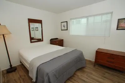a bedroom with a bed and a mirror and a window at 3 Bedrooms in Newport Beach