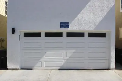 a white garage door with a sign on it at 3 Bedrooms in Newport Beach