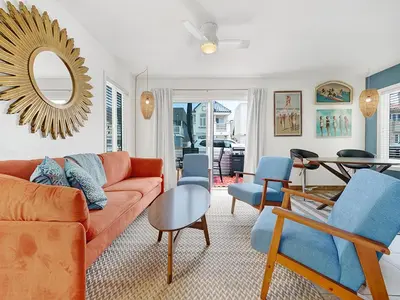a living room with a orange couch and blue chairs at 3 Bedrooms in Newport Beach