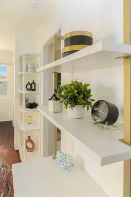 a room with white shelves with a clock and a plant at Stylish 1Br Retreat With Garage AC Close 2 Everything in San Diego