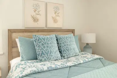 a bedroom with a bed with blue and white pillows at Elegant 3Br Home with AC, Parking, & Close 2 Everything in San Diego