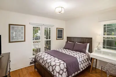 a bedroom with a bed and a desk and windows at Elegant 3Br Home with AC, Parking, & Close 2 Everything in San Diego