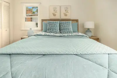 a large bed with a blue comforter and pillows at Elegant 3Br Home with AC, Parking, & Close 2 Everything in San Diego