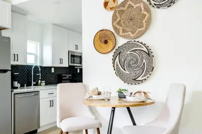 a kitchen with white cabinets and a table and chairs at Chic 2Bed And Large Serene Backyard in Heart of SD in San Diego