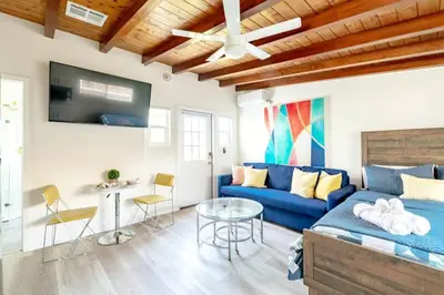 a living room with a blue couch and a table at Chic Studio Suite Serene Backyard in Heart of SD in San Diego