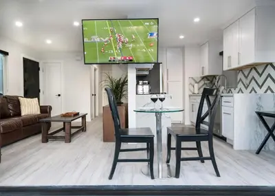 a kitchen and living room with a tv on the wall at Upper West Newport in Newport Beach