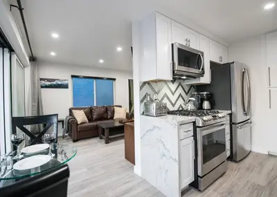 a kitchen with a stove top oven next to a living room at Upper West Newport in Newport Beach