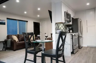 a kitchen and living room with a table and chairs at Upper West Newport in Newport Beach