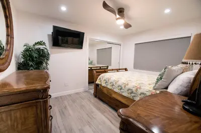 a bedroom with a bed and a dresser and a television at Upper West Newport in Newport Beach