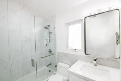 a white bathroom with a shower and a sink at 3 Bedrooms in Newport Beach