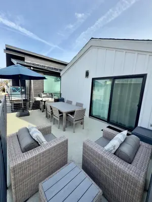 a patio with two couches and a table and an umbrella at 3 Bedrooms in Newport Beach