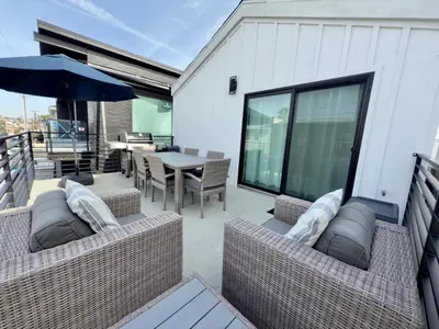 a patio with a table and chairs and an umbrella at 3 Bedrooms in Newport Beach