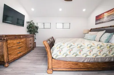 a bedroom with a bed and a dresser and a tv at 3 Bedrooms in Newport Beach