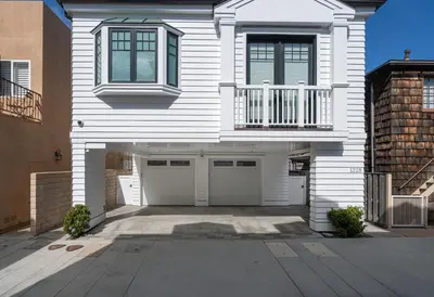 a white house with a garage and a balcony at 1225 W Balboa Blvd A in Newport Beach