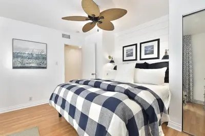 a bedroom with a black and white bed with a ceiling fan at 129 G St in Newport Beach