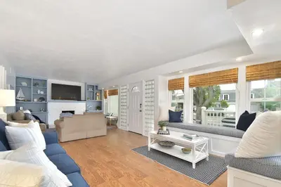 a living room with a blue couch and a living room with a tv at 129 G St in Newport Beach