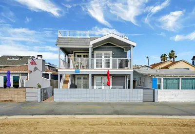 a white house with a balcony on a street at 1404 W Oceanfront A in Newport Beach