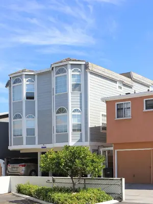 a gray building with white windows on a street at 1404 W Oceanfront A in Newport Beach