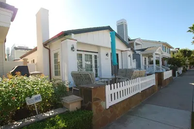 a white house with chairs and a fence at 1759 Miramar Dr in Newport Beach