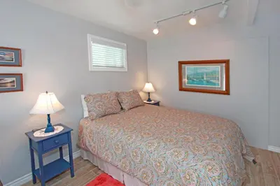 a bedroom with a bed and a table with two lamps at 1759 Miramar Dr in Newport Beach
