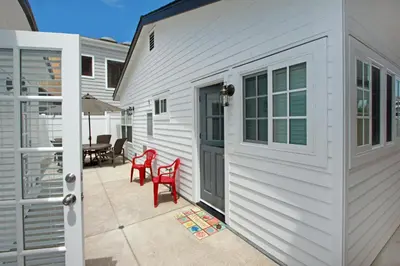 a white house with red chairs and a patio at 1759 Miramar Dr in Newport Beach