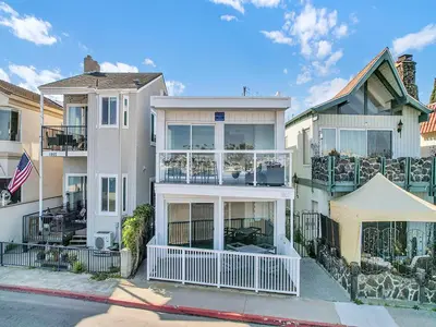 a white house with balconies on a street at 1807 W Bay Unit B in Newport Beach