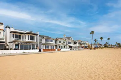 a row of houses on a beach with palm trees at 204 E Oceanfront B in Newport Beach